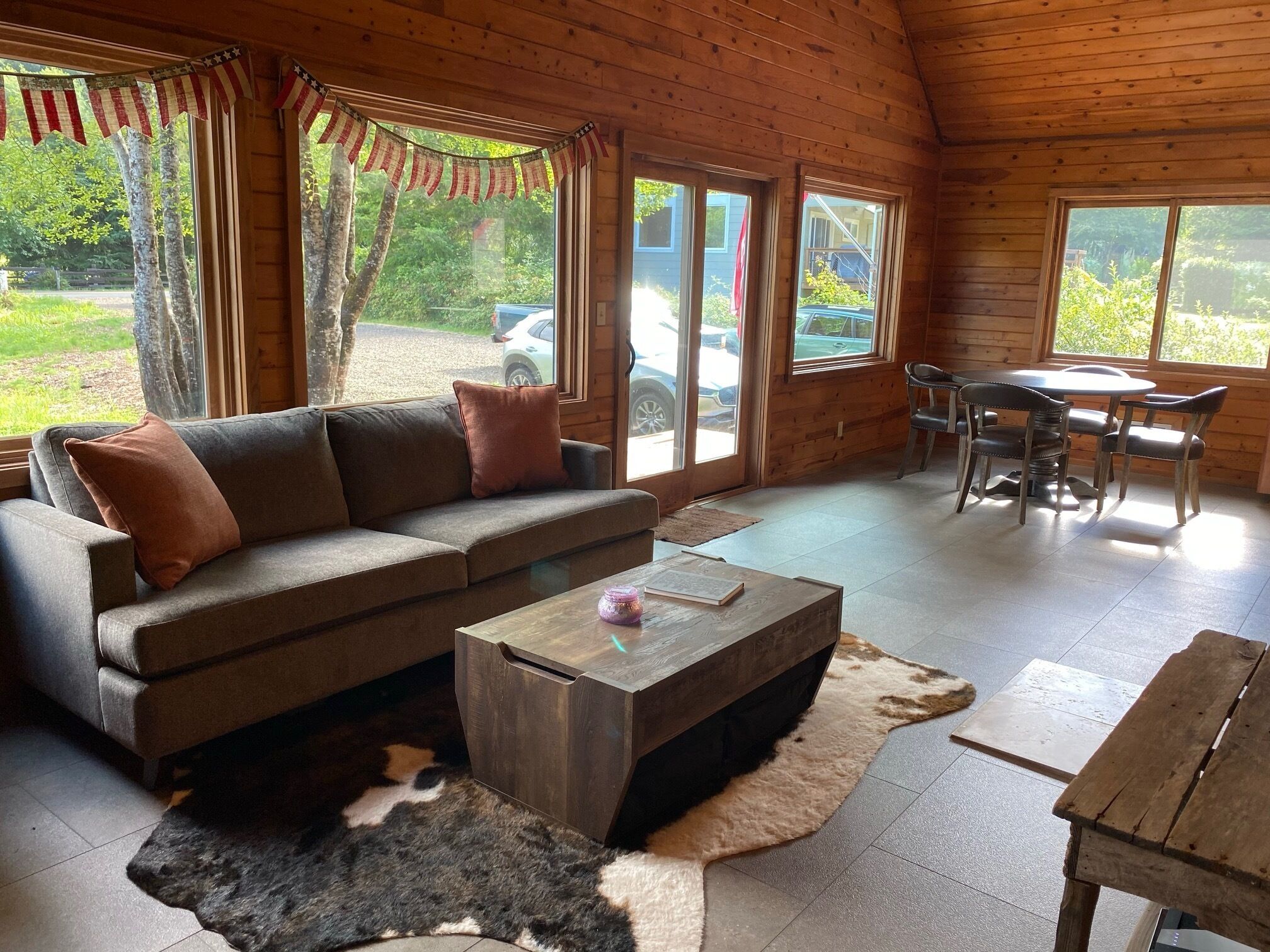 Ein gemütliches Blockhausschlafzimmer mit einer Couch, einem Couchtisch und einem Esstisch.