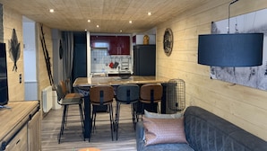 A compact living space with a kitchen area, dining table, and seating arrangement.