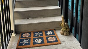 A wooden staircase with a doormat featuring sea-themed designs.