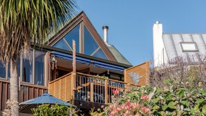 A modern house with a balcony, large windows, and a chimney. - Pointers - Akaroa Holiday Home (Akaroa)