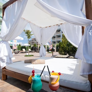 A sunbed under a white canopy with two drinks in front. - Siena Palace (Primorsko)