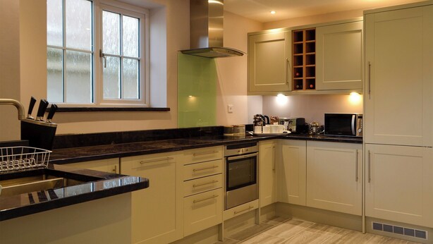 Una cocina moderna con ventana, electrodomésticos de acero inoxidable y muebles de cocina en tonos claros.