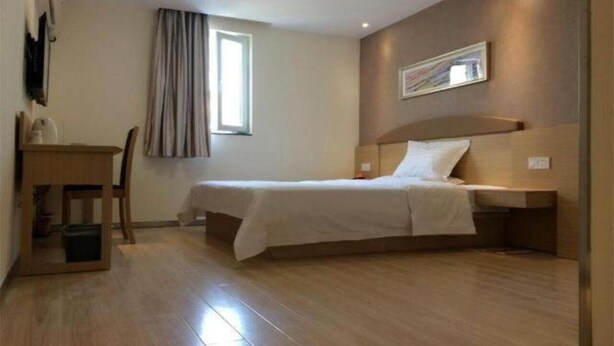 A bedroom with a bed, a desk, and a chair. - 7 Days INN Xingguang Avenue (Nanning)