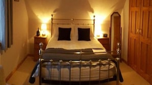 Ein Schlafzimmer mit einem Himmelbett, einem Holzschrank und einem Nachttisch mit Lampe.
