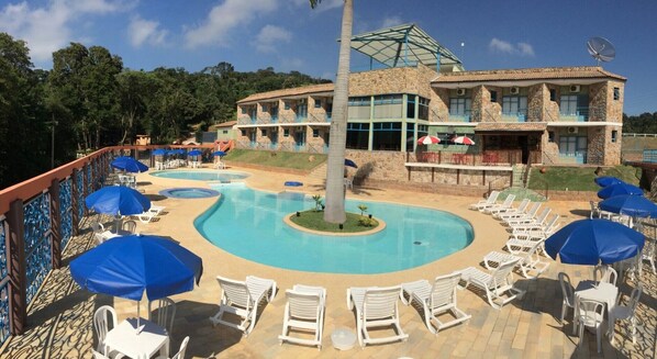 A resort with a large pool area, multiple lounge chairs, and umbrellas. - Quedasdagua Lazer e Hospedagem (Itu)