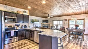 A spacious kitchen with dark cabinets, stainless steel appliances, and a large island.