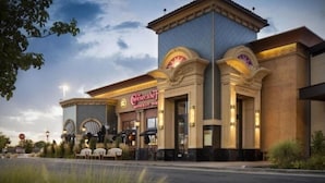 A Cheesecake Factory restaurant with a classic architectural design, featuring arched entrances and outdoor seating. - InTown Suites Extended Stay Salt Lake City UT - Midvale (Midvale)