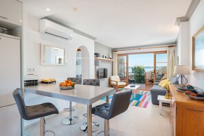 A modern kitchen with a dining area, large windows, and a view of the sea. - LORTAL apartment on the first line of the beach with swimming pools (Alcúdia)