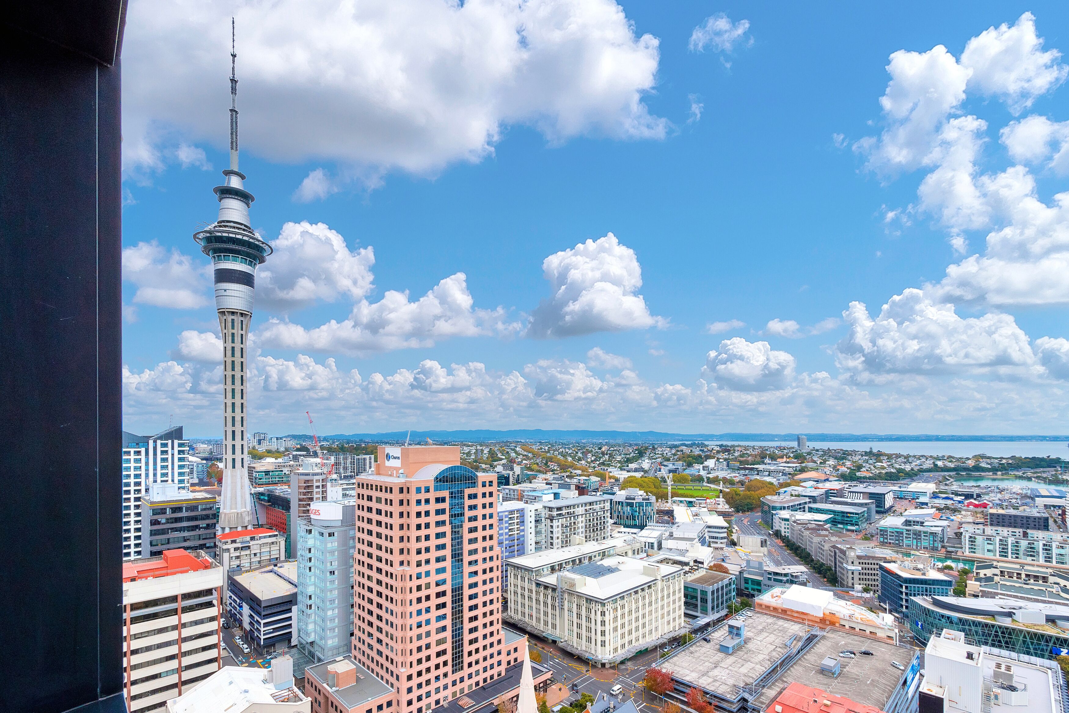 A cityscape with a prominent tower, various buildings, and a clear sky.