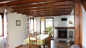 A dining area with a wooden ceiling, a fireplace, and a table set for six.