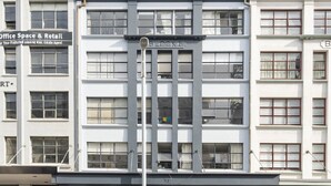 Un edificio a più piani dal design architettonico moderno, con un ingresso centrale ben visibile e un tetto piatto.