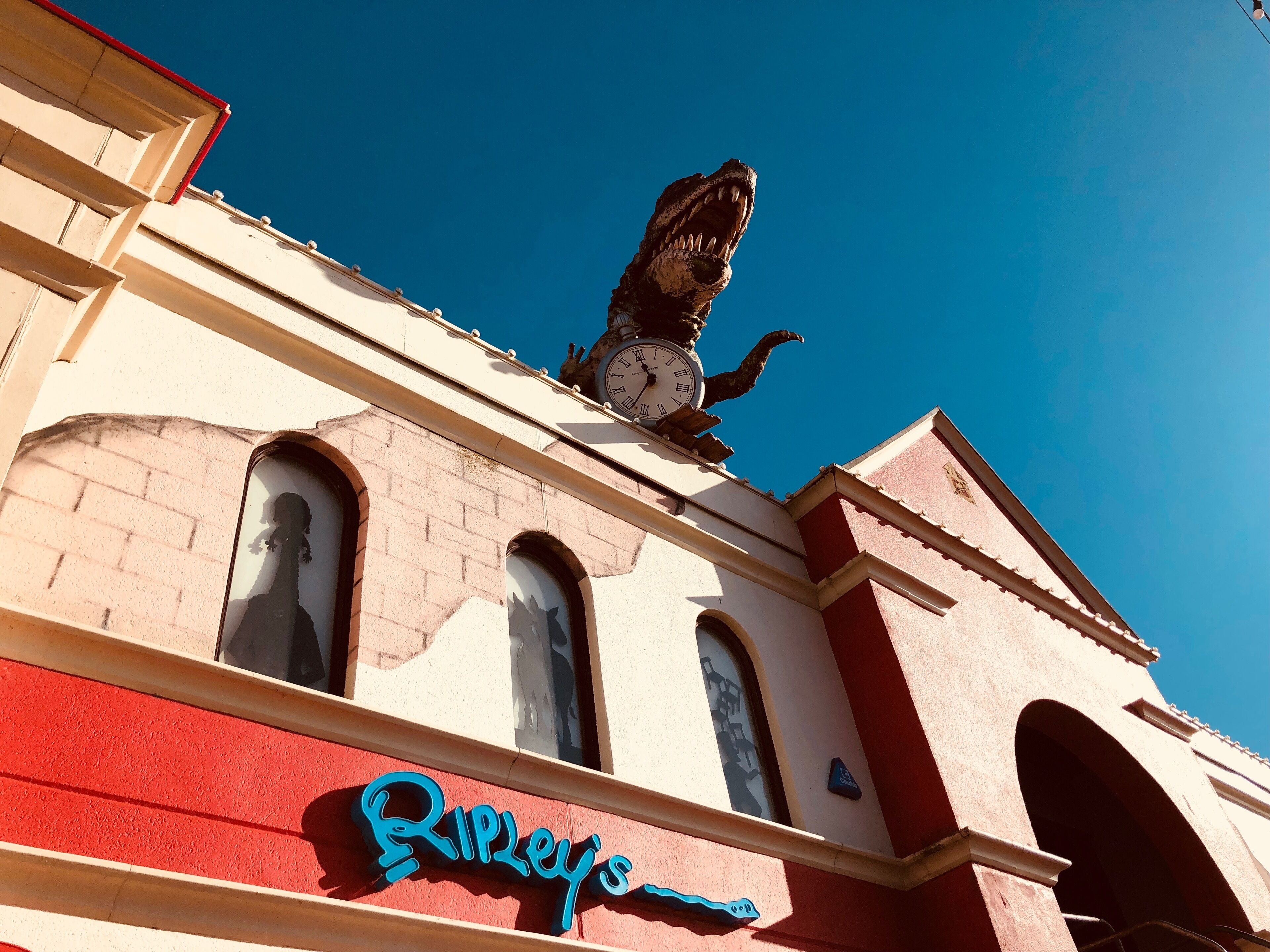 Un bâtiment surmonté d’une horloge et d’une statue de lion, avec un auvent rouge et une enseigne indiquant « Ripley’s ».