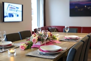 A dining table set with plates, glasses, and a floral centerpiece.