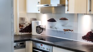 Eine moderne Küche mit Edelstahlgeräten, einer Kaffeemaschine und dekorativen Schüsseln auf der Arbeitsfläche.