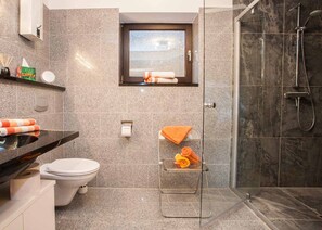 Ein modernes Badezimmer mit Toilette, Waschbecken und Dusche.