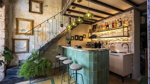 Une cuisine avec un coin bar, un escalier et des tabourets de bar.