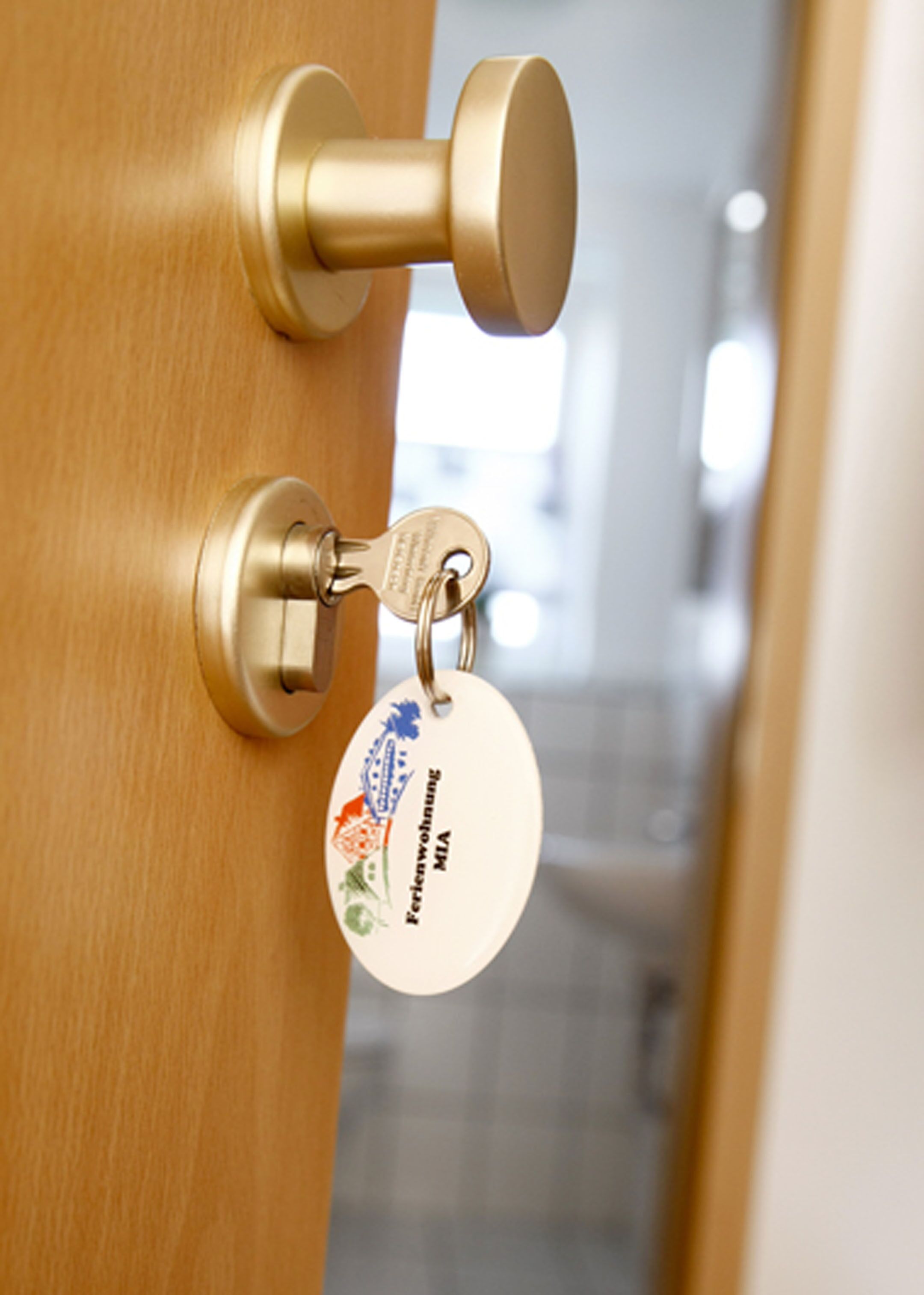 A brass door handle with a keyring attached.