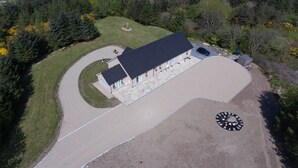 An aerial view of a house with a curved driveway, a garage, and a landscaped yard. - Apartment totally private entrance, sauna, shower, bedroom, studio,bathroom.     (Ballynahinch)