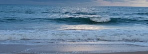 A beach with waves crashing onto the shore.