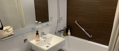 Une salle de bain moderne avec un lavabo blanc, un miroir et une douche.