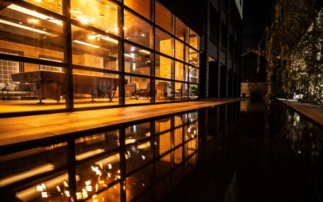 A modern building with large windows reflecting lights and a polished floor.