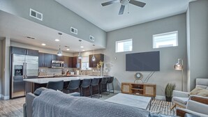 A modern kitchen with a central island, bar stools, and a dining area. - Wonderful Three Bedroom Townhome in Old Town North (Fort Collins)