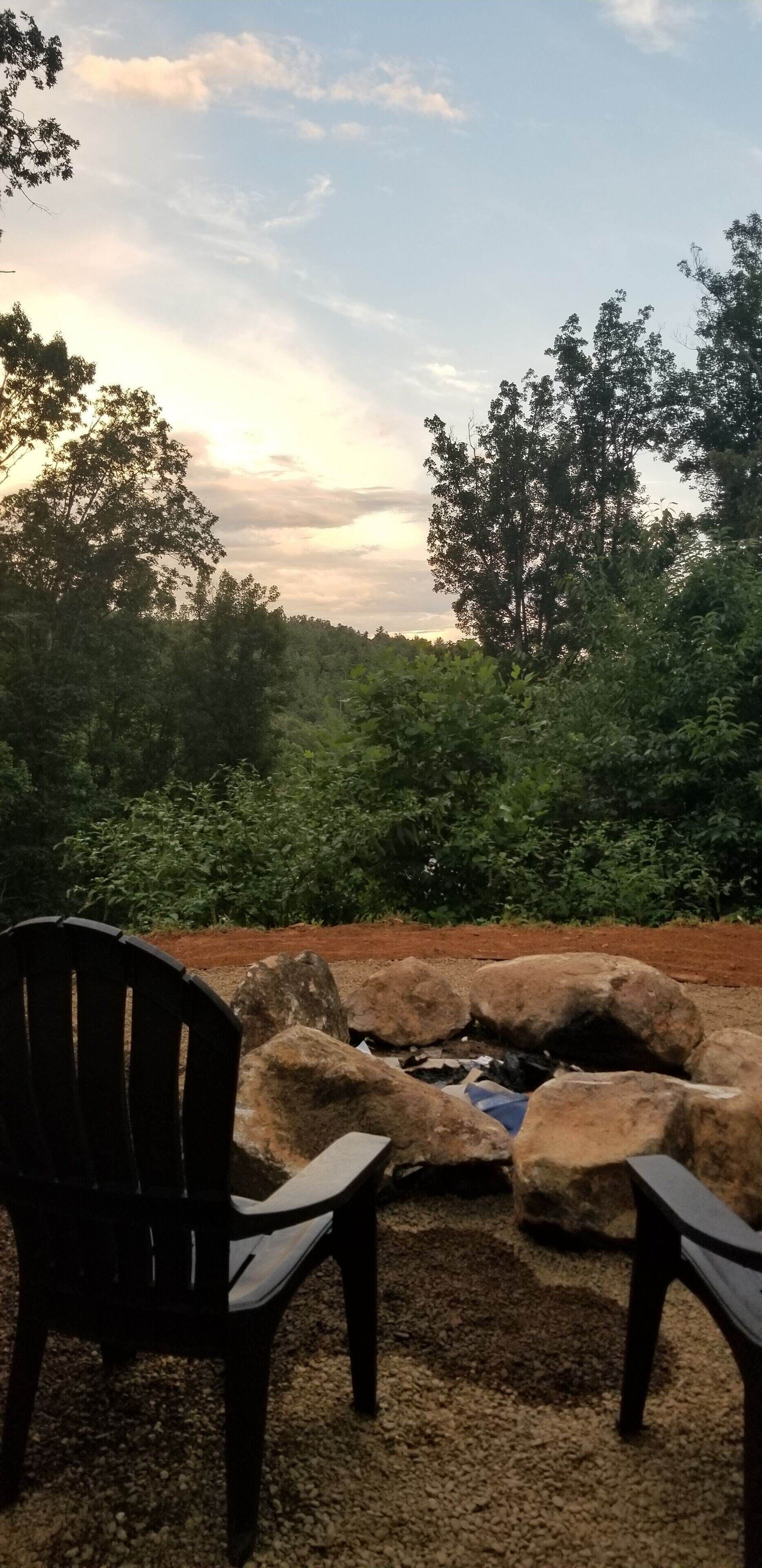 Zona relax con due poltrone rivolte verso un paesaggio naturale, che include una formazione rocciosa e una vegetazione lussureggiante.