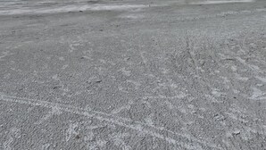 Hiekkaranta, ja kauempana horisontissa näkyy vene.