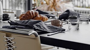 A dining table with croissants, coffee cups, and glasses, set against a large window with a view of palm trees and a balcony. - Months and Seasons - Coastal House - Stunning Views (Separation Creek)