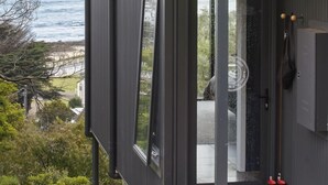 A modern building with large windows overlooking a coastal view. - Months and Seasons - Coastal House - Stunning Views (Separation Creek)