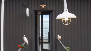 A corridor with a view of the sea, leading to a balcony with a railing. - Months and Seasons - Coastal House - Stunning Views (Separation Creek)