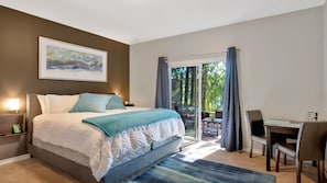 Relax in a spacious room with a large bed, desk, and patio access.