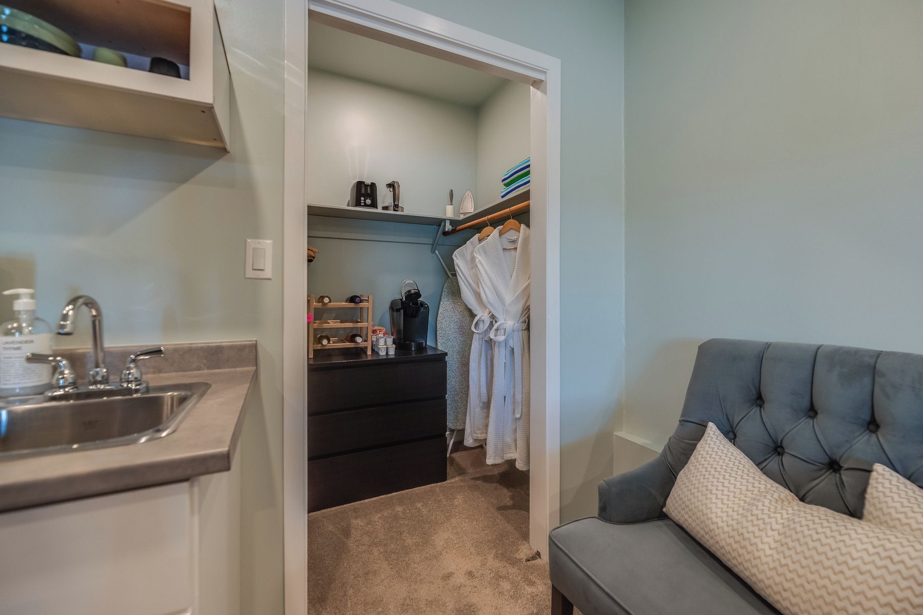A bathroom with a sink, a mirror, and a towel rack.