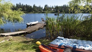 Un moll al costat del llac amb una barca, una pala i fons flotants.