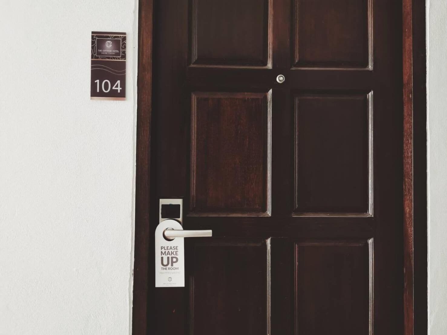 Una puerta de madera oscura con un letrero que indica la habitación número 104.
