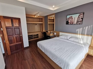 A bedroom with a bed, a desk, and a wardrobe. - The Cottage Hotel Udon Thani (Udon Thani)