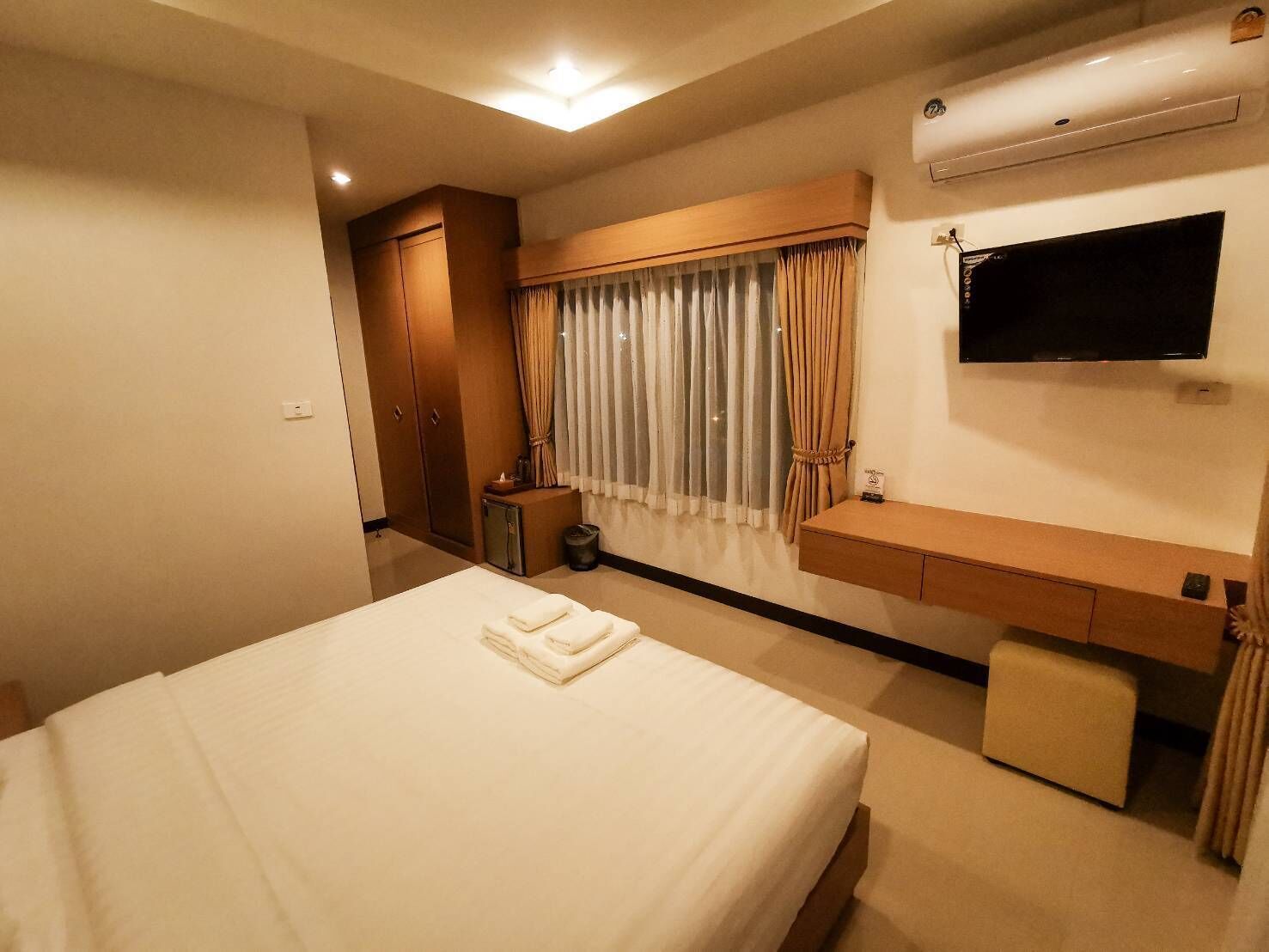 Une chambre d’hôtel équipée d’un lit, d’une télévision, d’un bureau et d’une armoire.