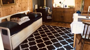 Una habitación acogedora de estilo cabaña con una cama, una kitchenette pequeña y un ventanal con vistas.