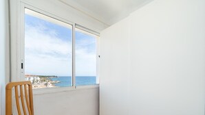 A balcony with a wooden chair and a view of the sea and buildings. - Heart of the village sea views only 100m beach (L'Ametlla de Mar)
