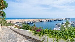 A coastal marina with boats docked, a stone-paved walkway, and a view of the sea. - Heart of the village sea views only 100m beach (L'Ametlla de Mar)