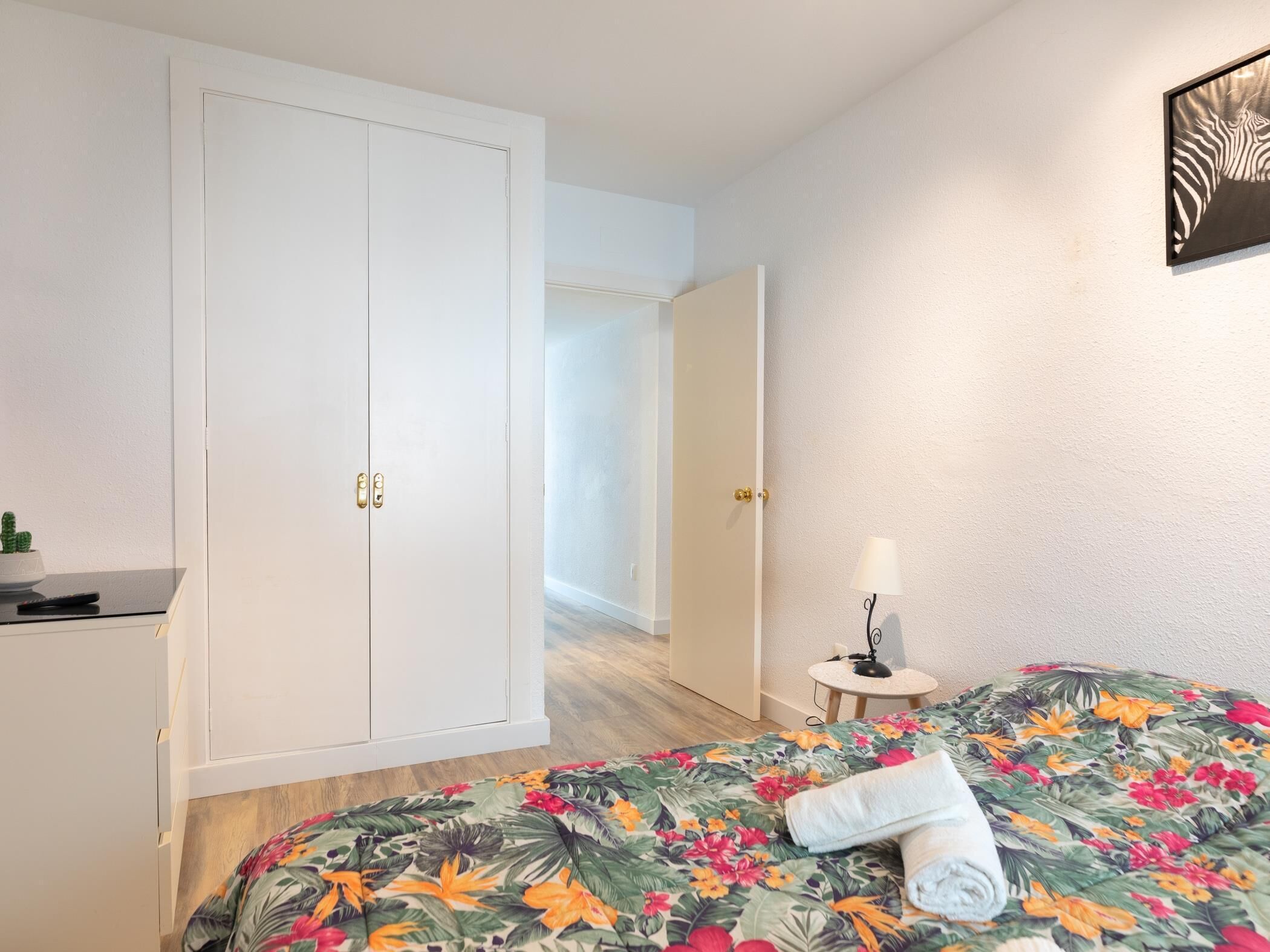 Una habitación de hotel con cama, escritorio y armario.