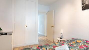 Una habitación de hotel con cama, escritorio y armario.