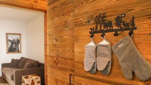 A wooden wall with a coat rack holding two grey mittens and a wooden wall with a coat rack holding two grey mittens. - Papillon by Interhome (Zermatt)