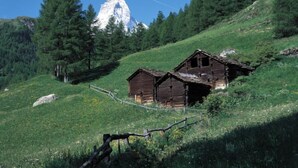 A rustic wooden cabin on a hillside with a mountain in the background. - Papillon by Interhome (Zermatt)