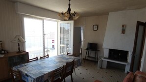 Ein Essbereich mit einem Tisch für vier Personen, einem Fernseher und einem Kamin.