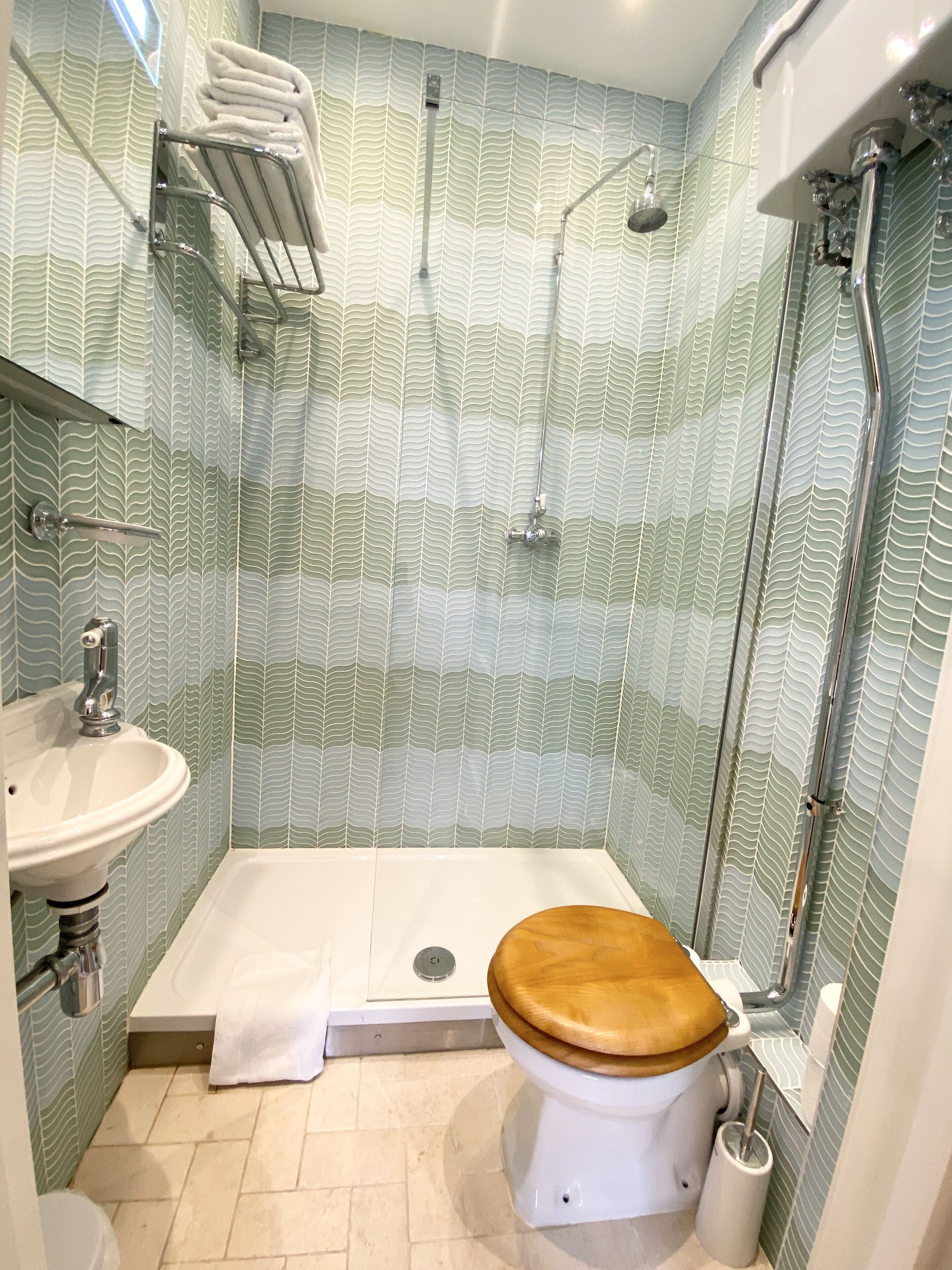 A bathroom with a shower, toilet, and sink.
