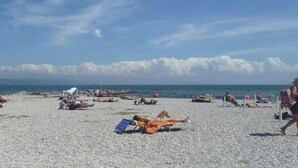 Uma praia com pessoas tomando sol e relaxando.