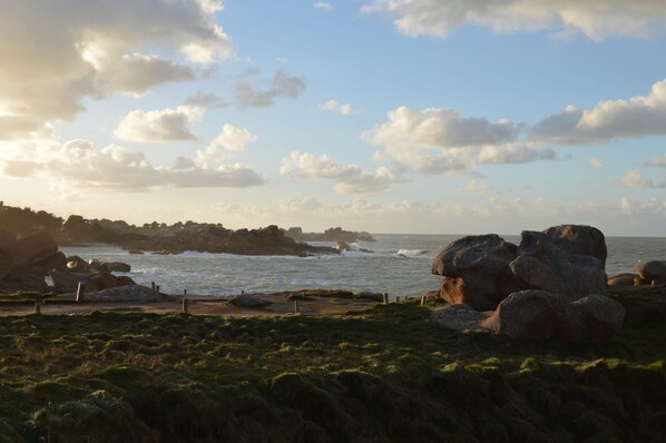 A coastal landscape with rocky outcrops, grassy terrain, and a view of the sea. - Arty, self-contained accomodation on "la cote de granit rose" 800m from the Breton sea (louannec)