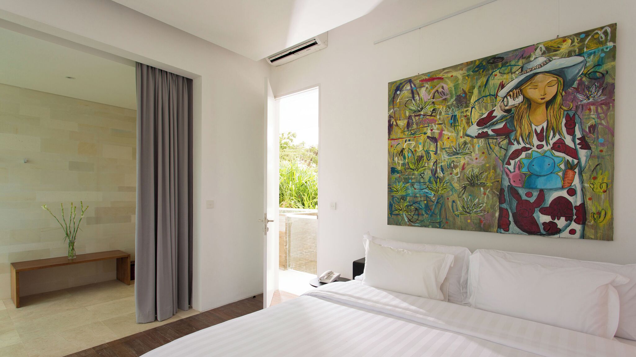 Une chambre à coucher moderne avec un grand lit, un tableau au mur et un balcon avec des rideaux.
