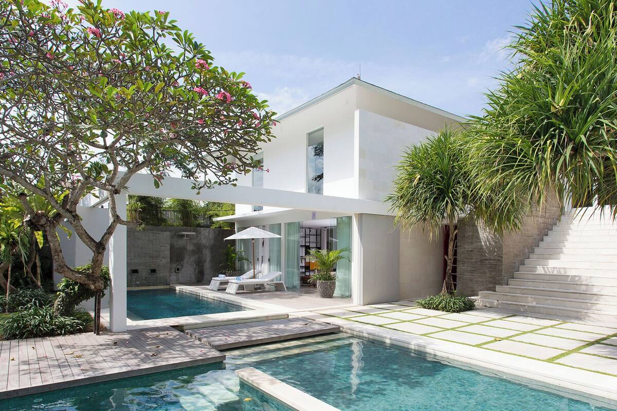 A modern house with a swimming pool, a covered patio, and a staircase.